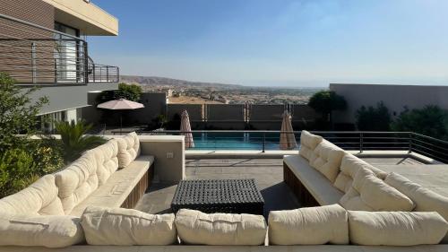 a living room with white couches and a pool at Stay Chalet Deadsea in Ash Shāghūr