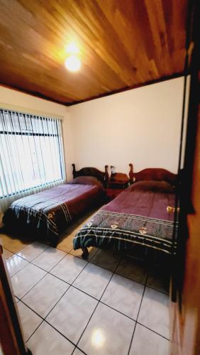 1 Schlafzimmer mit 2 Betten in einem Zimmer in der Unterkunft Don Carlos Place in Alajuela