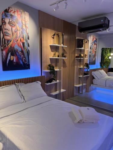 a bedroom with a large white bed and a couch at Studio Automatizado Novo Proximo Av Paulista in Sao Paulo