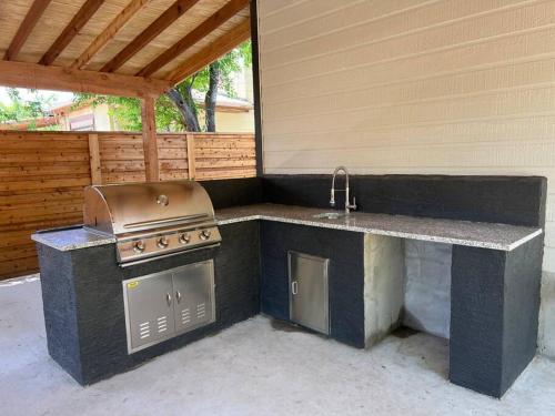 a outdoor kitchen with a stove and a sink at The Retreat at Rigsby-All new 3bdrm/2.5 bath in San Antonio