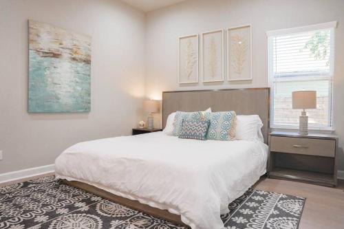 a bedroom with a large white bed and a window at The Retreat at Rigsby-All new 3bdrm/2.5 bath in San Antonio