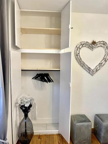 a room with a heart on the wall and a vase with flowers at NEW PROCHE NAUSICAA ! « Mille et Un Rêve » in Boulogne-sur-Mer