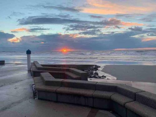 a sunset over the ocean with a lighthouse on the beach at NEW PROCHE NAUSICAA ! « Mille et Un Rêve » in Boulogne-sur-Mer