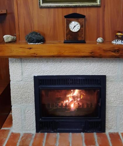 a fireplace with a clock on top of it at VuT El Pozo la Carrera in San Pedro de Gaíllos