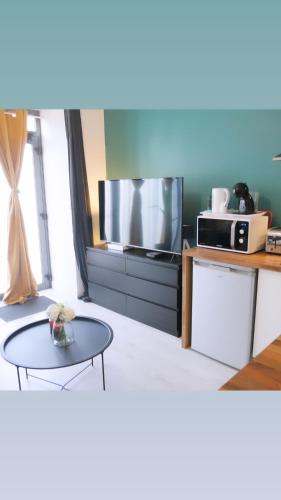 un salon avec une télévision et une table basse dans l'établissement Joli studio dans le centre ville de Brest, à Brest