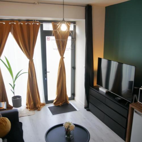 un salon avec une télévision et une table dans l'établissement Joli studio dans le centre ville de Brest, à Brest