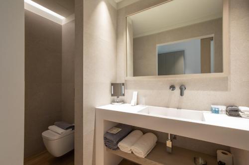 a bathroom with a sink and a mirror and a toilet at Fabrikas in Mýkonos City