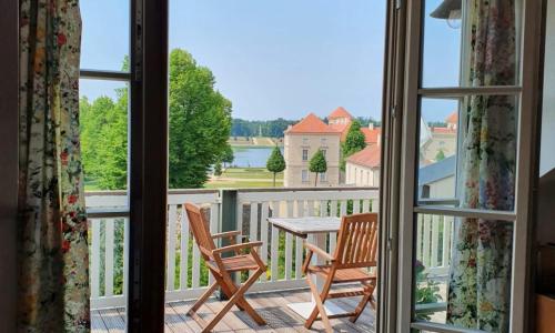 Habitación con vistas a un balcón con mesa y sillas. en LoggiaHaus am Schloss, 5 Ferienwohnungen, teils mit Schloss- und Seeblick, en Rheinsberg
