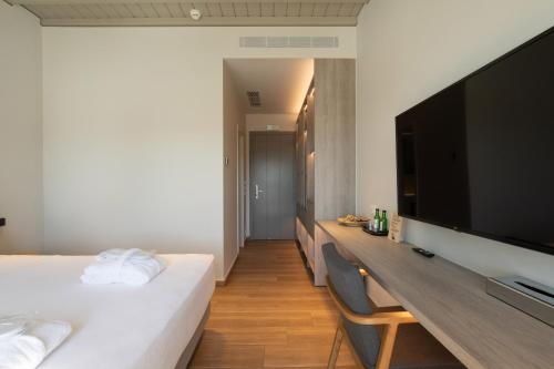 a bedroom with a large flat screen tv and a bed at Fabrikas in Mýkonos City