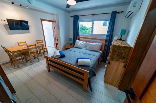 a bedroom with a bed and a table and a dining room at Todo Bien Quality Studio Beachfront Kite Beach in Cabarete