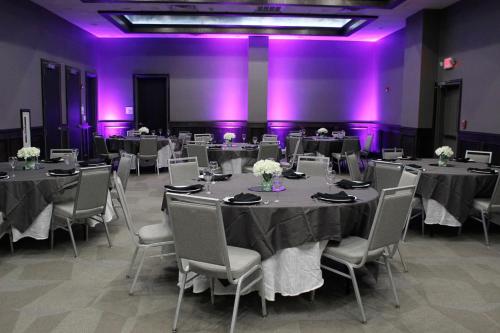 a room with tables and chairs with purple lights at Holiday Inn Hattiesburg - North by IHG in Hattiesburg