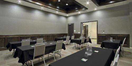a conference room with black tables and chairs and a mirror at Holiday Inn Hattiesburg - North by IHG in Hattiesburg