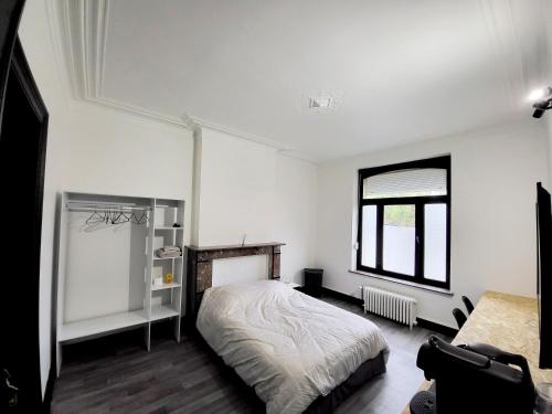 ein weißes Schlafzimmer mit einem Bett und einem Fenster in der Unterkunft Private industrial room in center of Charleroi in Charleroi