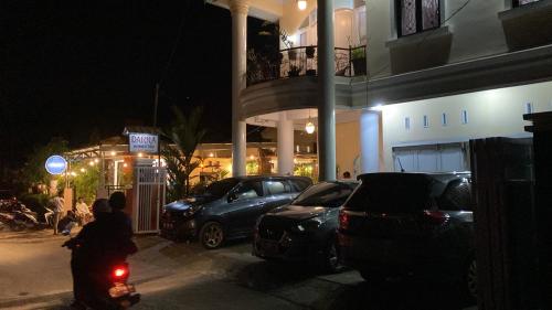un parking avec des voitures garées devant un bâtiment dans l'établissement DARRA HOMESTAY TORAJA, à Rantepao