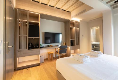 a hotel room with a bed and a desk and a television at Fabrikas in Mýkonos City