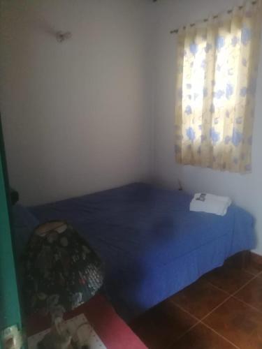 a bedroom with a blue bed and a window at Hotel Boutique La Cueva de la Luna, El Arte se hace Descanso in Duitama