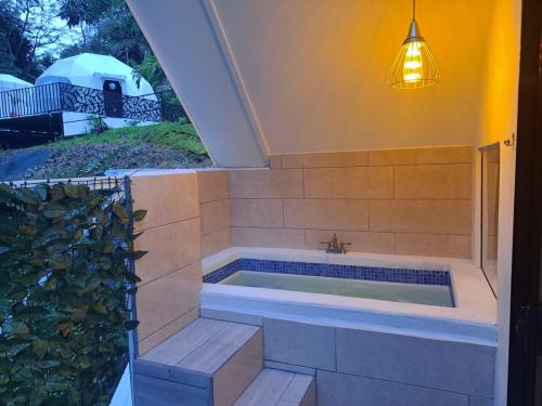uma banheira num quarto com uma janela em HOTEL, VILLAS y GLAMPINGS MYA -PUERTO VIEJO, Limon, CR em Puerto Viejo