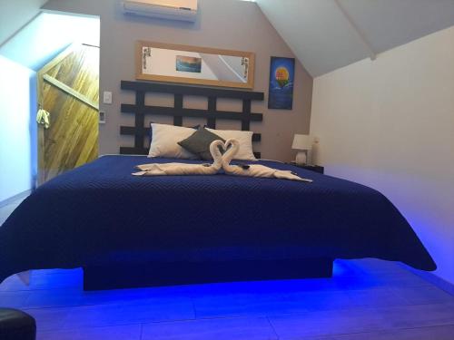 a bedroom with a large bed with blue lighting at HOTEL, VILLAS y GLAMPINGS MYA -PUERTO VIEJO, Limon, CR in Puerto Viejo