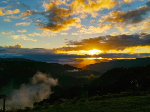 a sunset in the mountains with the sun setting at Hotel Kasama in San Agustín