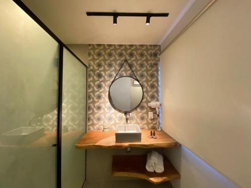 a bathroom with a vanity and a mirror on a wall at Pousada Renda do Mar in Morro de São Paulo