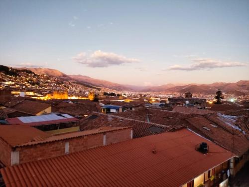 Blick auf eine Stadt mit Dächern und Bergen in der Unterkunft Hospedaje de la cuba in Cusco