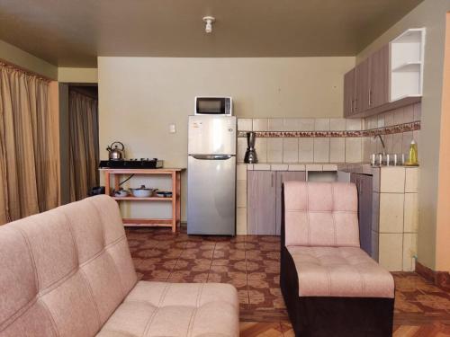 Il comprend une cuisine avec deux chaises et un réfrigérateur. dans l'établissement Hospedaje de la cuba, à Cusco