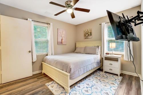 Schlafzimmer mit einem Bett und einem Deckenventilator in der Unterkunft Cozy, 1-Level Cottage - 5 miles to Uptown CLT in Charlotte