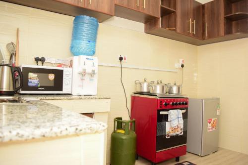 eine Küche mit einem roten Herd und einem Kühlschrank in der Unterkunft Laucinas homes in Nakuru