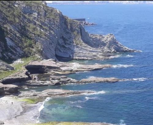 a view of a rocky shore with the ocean at Apartamento Puente Colgante in Getxo