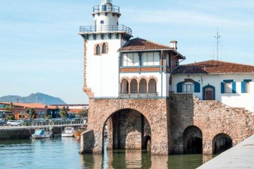 a lighthouse sitting on top of a body of water at Apartamento Puente Colgante in Getxo