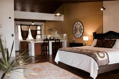 a bedroom with a large bed and a kitchen at Hotel Los Olivos Santiago Atitlan in Santiago Atitlán