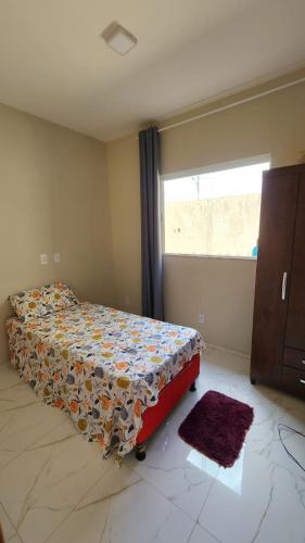 1 dormitorio con 1 cama en una habitación con ventana en Casa do Jerff en Viçosa do Ceará