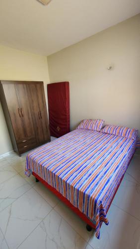 1 cama grande en un dormitorio con armario de madera en Casa do Jerff en Viçosa do Ceará