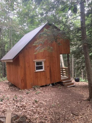 Cabaña de madera pequeña en el bosque con ventana en Vana Kuti-cabin in the woods, en Camden