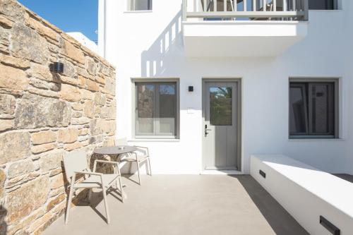 a patio with a table and chairs next to a brick wall at Fabrikas in Mýkonos City