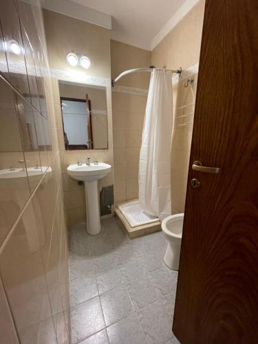 y baño con ducha, lavabo y aseo. en Edificio San Martin 2468 en Mar del Plata