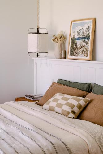 a bedroom with a bed with a checkered blanket at Upland Farm Luxury Cabins, Denmark Western Australia in Denmark