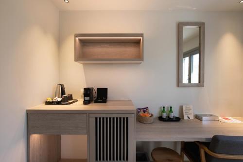 a desk in a room with a microwave and a mirror at Fabrikas in Mýkonos City
