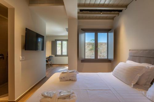 a bedroom with a large white bed with towels on it at Fabrikas in Mýkonos City