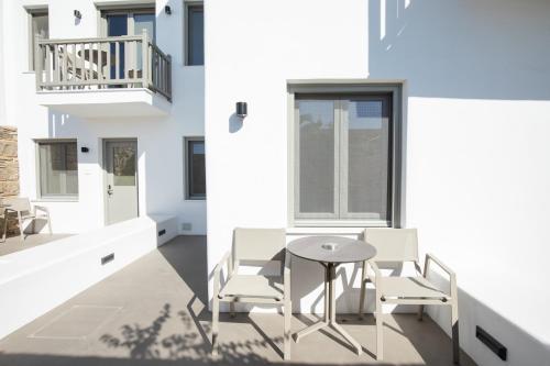 a white house with a table and chairs on a balcony at Fabrikas in Mýkonos City