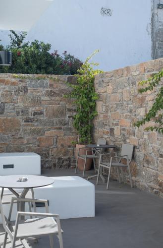 a patio with tables and chairs and a brick wall at Fabrikas in Mýkonos City