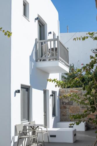 a white building with two chairs and a balcony at Fabrikas in Mýkonos City