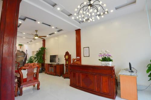 a living room with a clock and wooden furniture at Khách Sạn Đông Phương in Lạng Sơn
