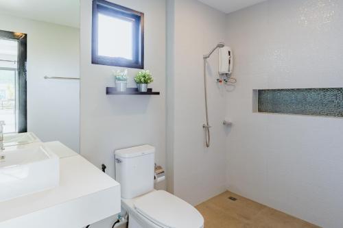 a white bathroom with a toilet and a sink at PP Pool Villa Huahin in Hua Hin