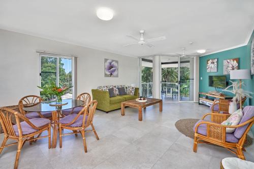 a living room with a table and chairs at Golden Sands Beachfront Resort in Yorkeys Knob