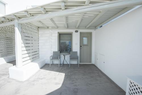 a white patio with a table and chairs at Fabrikas in Mýkonos City