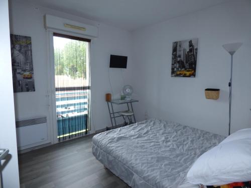 une chambre avec un lit, une fenêtre et une table dans l'établissement Appartement Cosy à Biscarrosse - 4 Pers, Centre-Ville, Parking, Balcon, Ménage Inclus - FR-1-319-445, à Biscarrosse