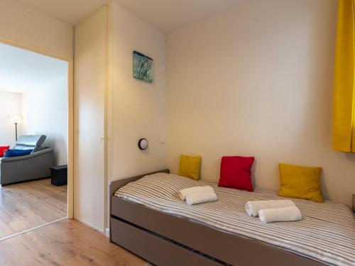 - une chambre avec un lit doté d'oreillers rouges et jaunes dans l'établissement Appartement T2 avec piscine, proche océan, linge et ménage inclus, à Biscarrosse Plage - FR-1-319-455, à Biscarrosse