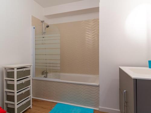 La salle de bains est pourvue d'une douche et d'une baignoire. dans l'établissement Appartement T2 avec piscine, proche océan, linge et ménage inclus, à Biscarrosse Plage - FR-1-319-455, à Biscarrosse
