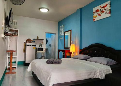 a bedroom with a large white bed with blue walls at Sala Bua Room in Karon Beach